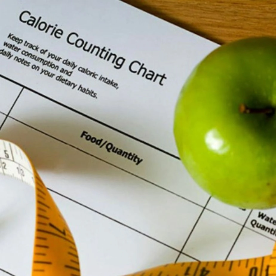 an apple measuring tape and calorie counting chart on the table